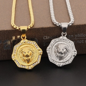 Detail of gold and silver lion head pendants with octagon frames and inlaid crystals