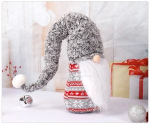 Close-up of a Christmas gnome doll featuring a gray knitted hat and red reindeer patterns