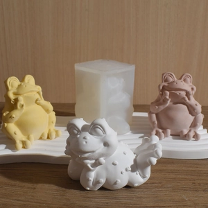 Detailed frog silicone mold with three colorful plaster figurines on a wave display tray