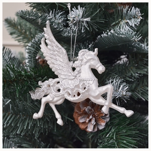 Close-up of white Pegasus Christmas ornament with glitter wings hanging on a tree