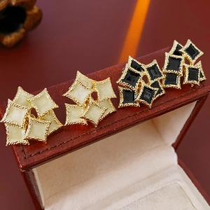 Detail of vintage square enamel earrings in beige and black on leather jewelry box