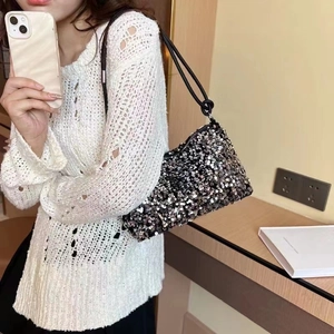 Sparkly black and silver sequin baguette bag with leather strap shown on a model