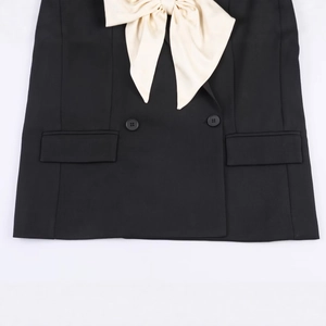 Women's black blazer jacket featuring a large cream contrast bow and double-breasted design