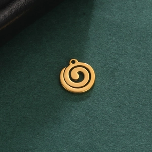 Macro view of a 18K gold-plated stainless steel spiral charm on green texture