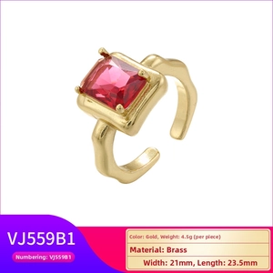 Detail of gold brass ring featuring a hammered texture and a red rectangular gemstone