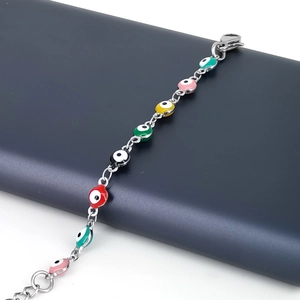 Détail de breloques œil maléfique colorées en émail sur un bracelet argenté avec fermoir
