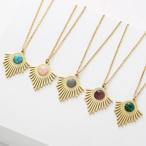 Détail de cinq colliers dorés avec des pendentifs en pierre naturelle multicolore