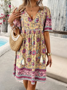 Detail of V-neck floral print dress with tassel drawstrings and bohemian border patterns