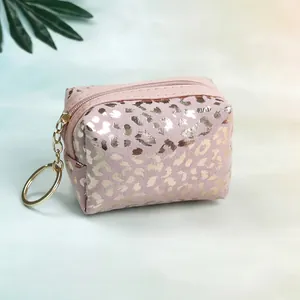 Detail of pink leopard print mini pouch with gold zipper and round metal keychain