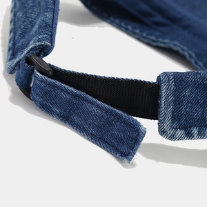 Detail of adjustable strap and denim texture on vintage sun visor hat in navy blue