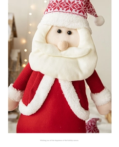 Detailed view of handmade knitted Santa doll with soft white beard and red festive hat