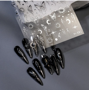 Detailed silver metallic embossed nail stickers with moon, stars, and butterfly motifs