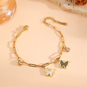 18k gold plated butterfly bracelet with zircon accents on a soft beige background
