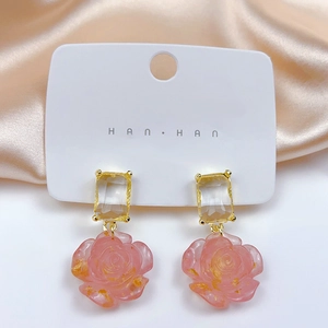 Detail view of pink rose drop earrings with clear square crystal and gold foil flakes