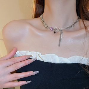 Silver chain necklace with purple heart gemstone and tassel on a model neck