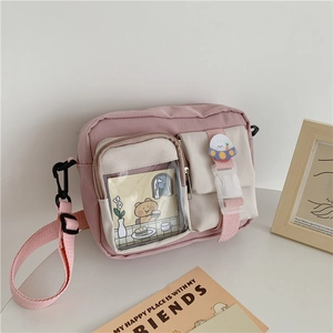 Detail of pink canvas crossbody bag featuring transparent pocket and astronaut bunny badge