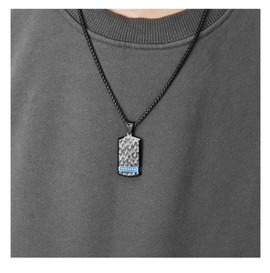 Detailed close-up of a men's black textured dog tag necklace with a blue gemstone inlay