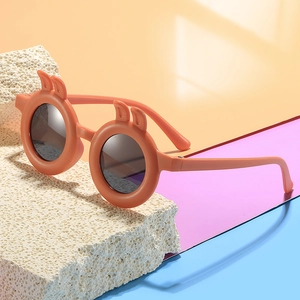 Orange round frame sunglasses for kids with cute bunny ears on colorful background