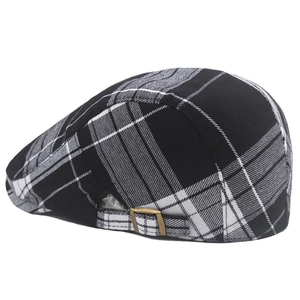 Detail of vintage black and white plaid newsboy hat with a bronze metal side buckle
