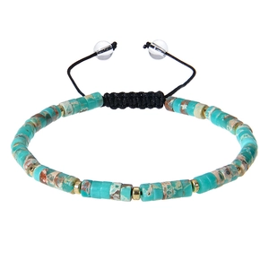Detail of turquoise natural stone beads with gold spacers on black braided cord