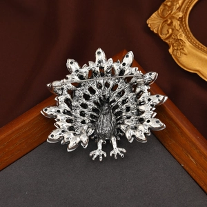 Vintage silver peacock brooch with sparkling rhinestones and detailed textured feathers