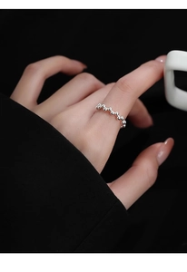 Detailed view of s925 sterling silver beaded ring on finger with dark background