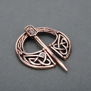 Detailed view of an antique bronze Celtic knot metal brooch and shawl pin fastener