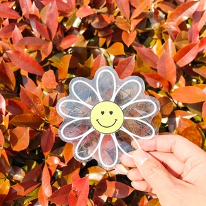 Macro shot of a flower suncatcher sticker with a yellow smiley face on static cling vinyl