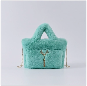 Detail of mint green faux rabbit fur handbag with gold chain strap and deer tassel charm