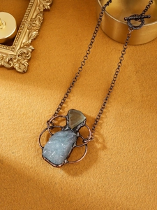 Detail of vintage bohemian aquamarine and green fluorite raw stone pendant with OT clasp