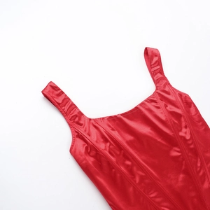 Close-up detail of smooth red satin fabric with square neckline and wide shoulder straps
