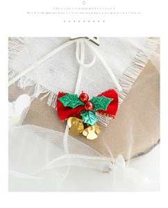 Vue détaillée du nœud de Noël rouge avec cloches dorées et feuilles vertes sur tulle blanc