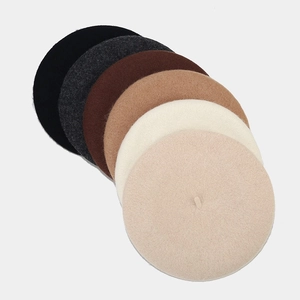 Detail van wolvilt textuur en kleurenpalet van zes minimalistische baret hoeden