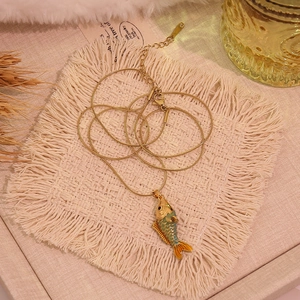 Détail du pendentif carpe koi doré vintage avec émail bleu et chaîne serpent titane
