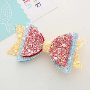 Close-up of a double-layered bow hairclip with colorful sequins and a yellow center strap
