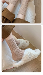 Detailed close-up of thick light brown cable knit warm socks with cozy plush slippers