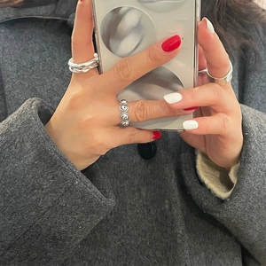 Close-up of three 925 sterling silver rings with smiley face pattern on a model