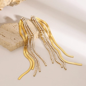 Detail of gold stainless steel tassel earrings with cubic zirconia and flat snake chains