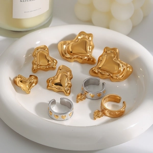 8-piece jewelry set with gold heart earrings and silver rings on white display plate