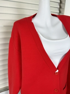 Detail of red V-neck knit cardigan showing the soft texture and matching buttons