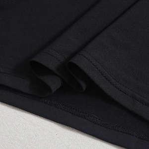 Détail macro du tissu en maille noire montrant les coutures de qualité et la texture mesh