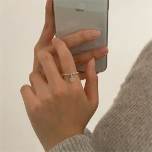 Detail of a 925 sterling silver beaded ring with a smooth round pendant on the index finger