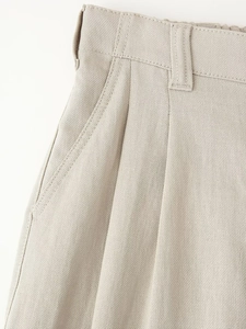 Close-up of beige sleeveless vest pants set featuring pleated waist and side pockets