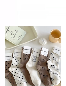 Detail von 6er-Pack süßen Cartoon-Bär- und Polka-Dot-Socken in warmen Herbstfarben