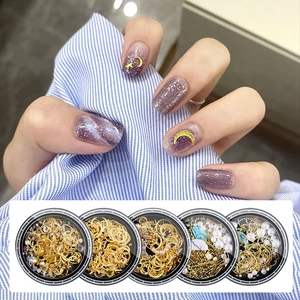 Nail art set featuring gold moon and star metal studs with pearls in five cases