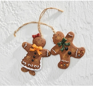 Macro view of resin gingerbread man ornaments with jute rope on white wall background