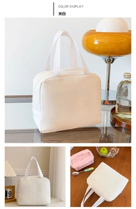 Close-up of cream-colored insulated lunch bag with zipper and sturdy fabric handles