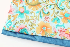 Detail von hellblauem Blumendruckgewebe vernäht mit dunkelblauem Denim-Material