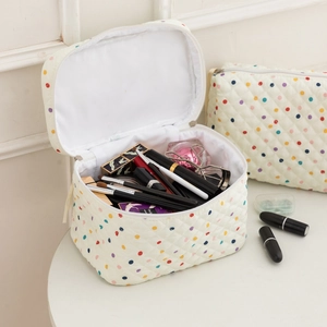 Detailed set of cream quilted cotton makeup bags with colorful polka dots and toiletries