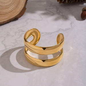 Detailed view of vintage gold-plated double-layer open bangle on a marble surface